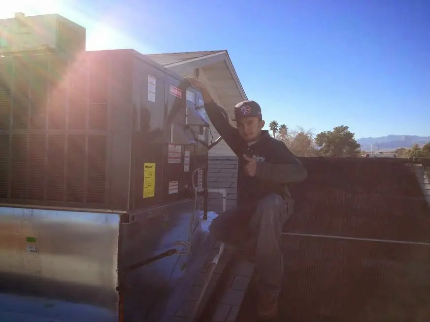 HVAC technician performing AC Tune-Up on a rooftop unit in Port LaBelle
